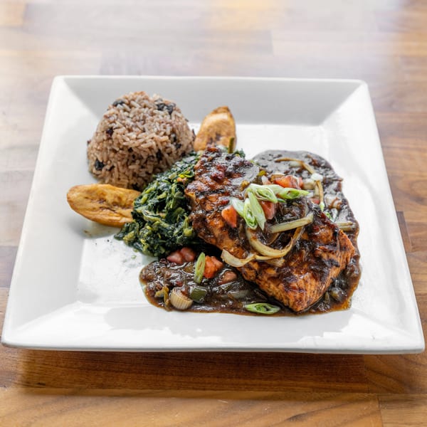 Grilled salmon with dark sauce, rice and beans, sauteed greens, and plantains on a white plate.